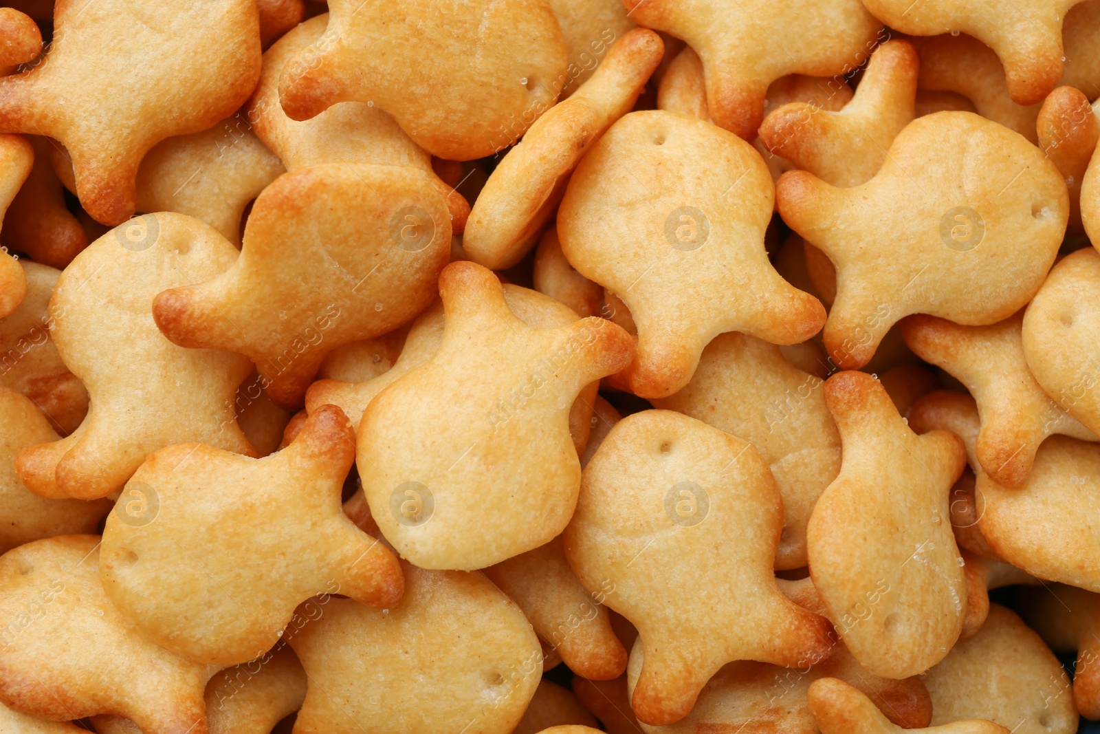 Photo of Delicious goldfish crackers as background, closeup view