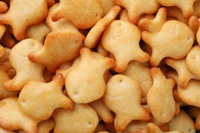 Delicious goldfish crackers as background, closeup view
