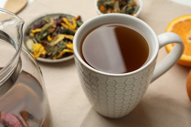 Cup of aromatic herbal tea on table, closeup