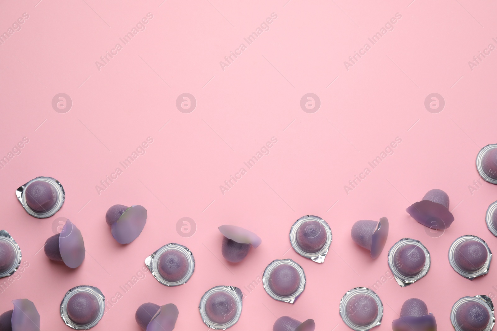 Photo of Tasty bright jelly cups on pink background, flat lay. Space for text