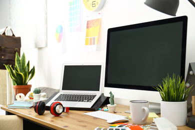 Photo of Modern laptop, computer and office supplies on wooden table, space for text. Designer's workplace