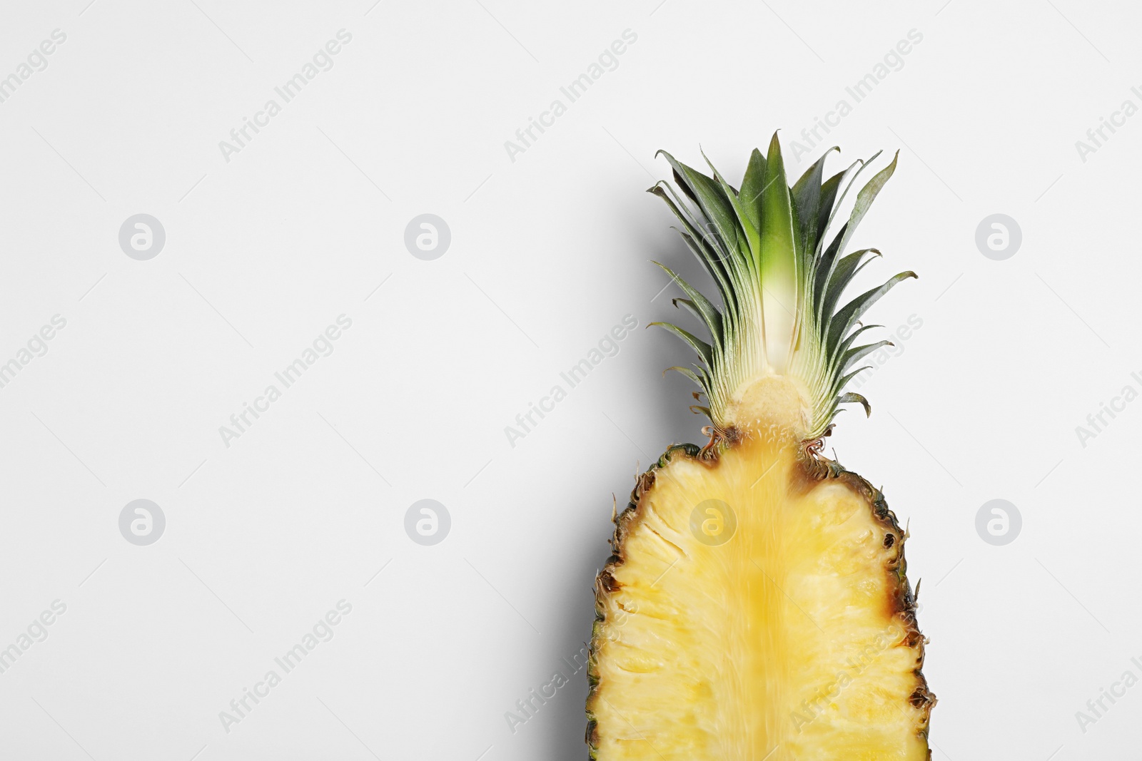 Photo of Half of raw pineapple on white background, top view