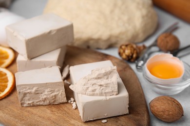 Yeast and ingredients for dough on table, closeup