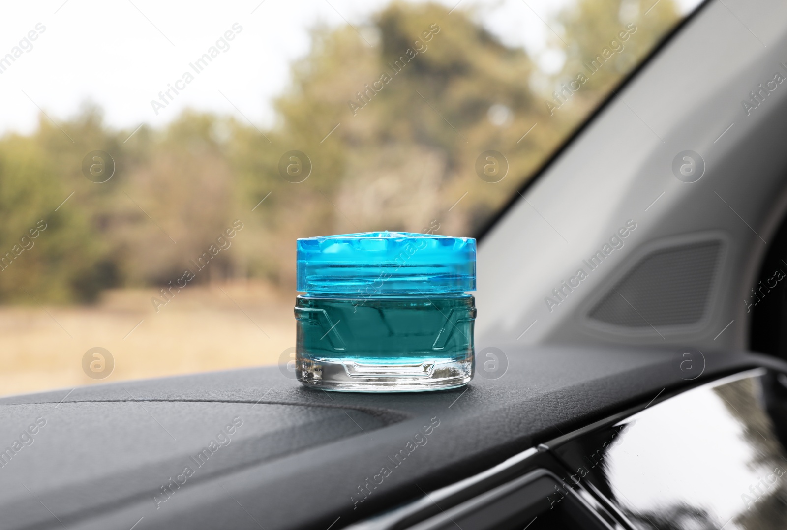 Photo of Stylish air freshener on dashboard in car