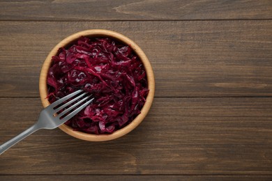 Photo of Tasty red cabbage sauerkraut on wooden table, top view. Space for text