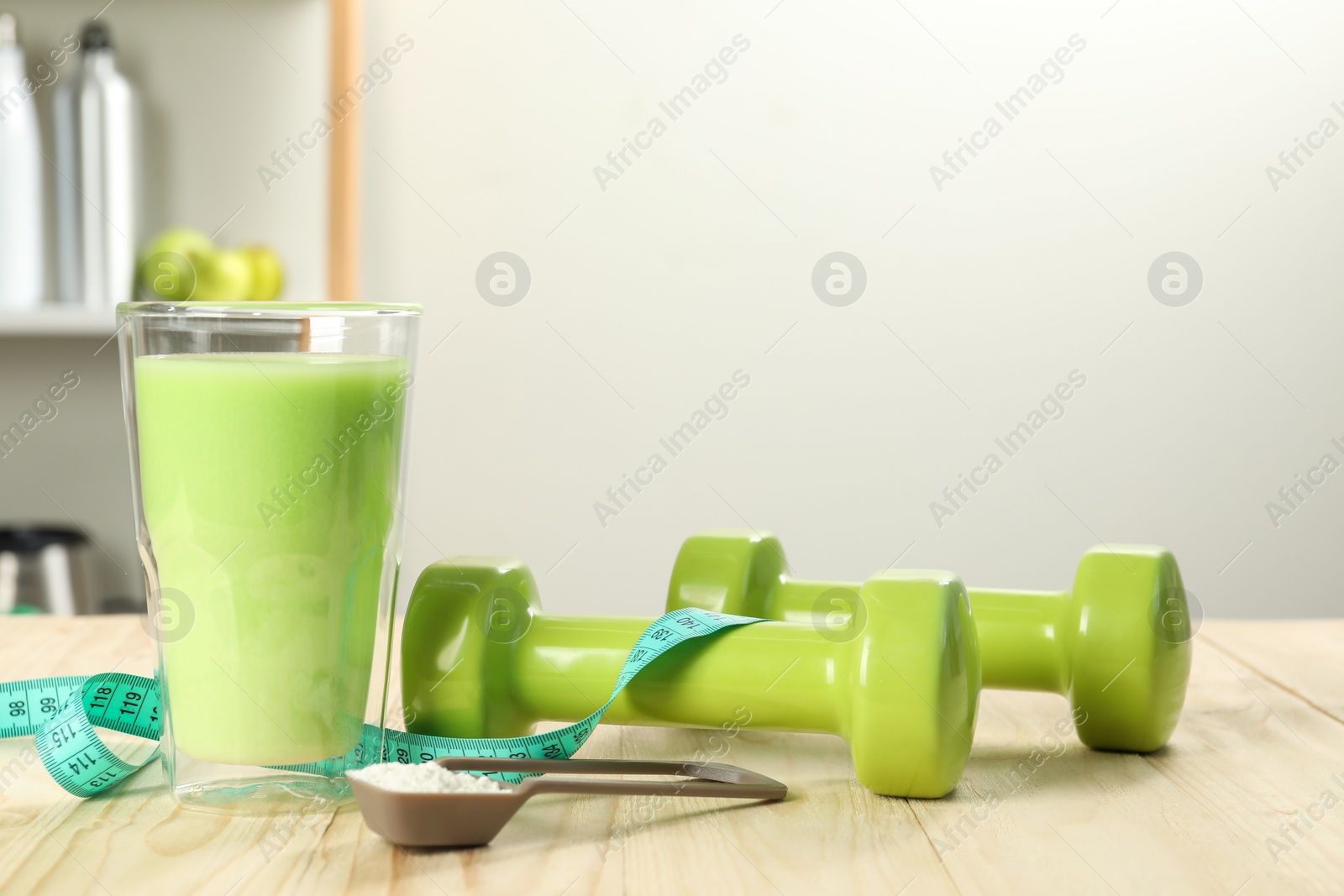 Photo of Tasty shake, dumbbells, measuring tape and powder on wooden table, space for text. Weight loss