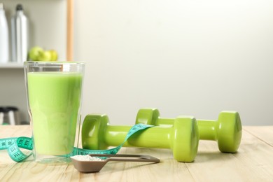 Photo of Tasty shake, dumbbells, measuring tape and powder on wooden table, space for text. Weight loss