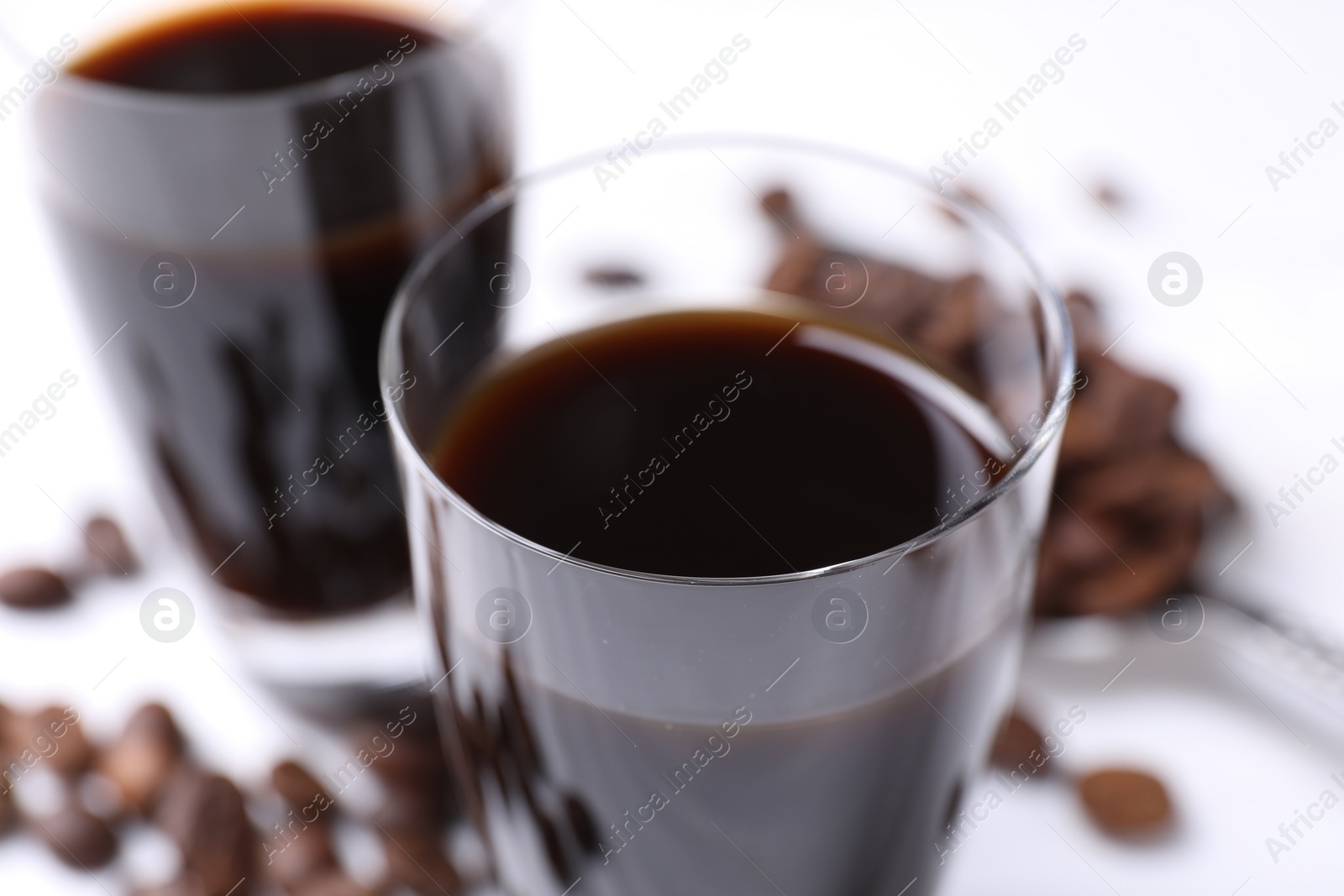 Photo of Glasses of coffee liqueur on blurred background, closeup