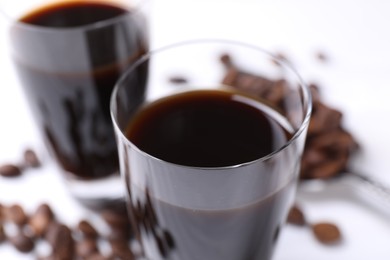 Glasses of coffee liqueur on blurred background, closeup