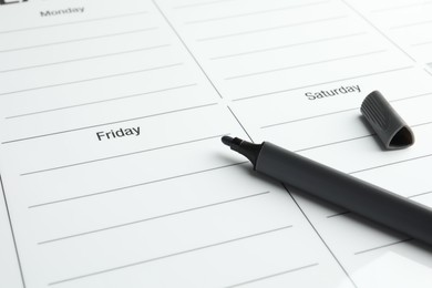 Photo of Timetable. Weekly planner and black felt pen, closeup