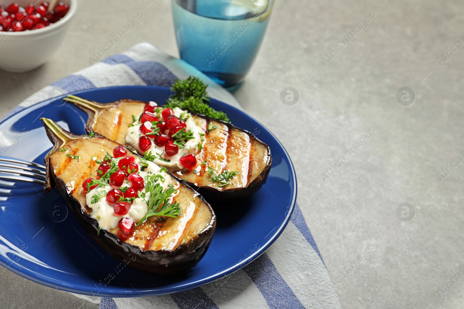 Photo of Plate with tasty fried eggplants on gray table. Space for text