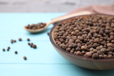 Photo of Peppercorns on light blue wooden table, closeup