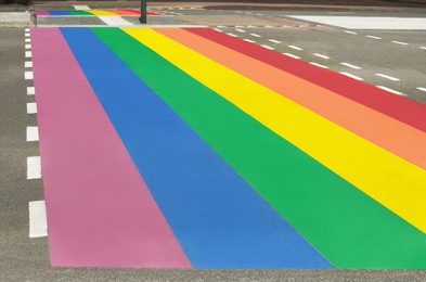 Photo of Bright rainbow LGBT pride flag on city road