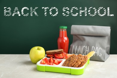 Image of Lunch box with appetizing food and bag on table near chalkboard
