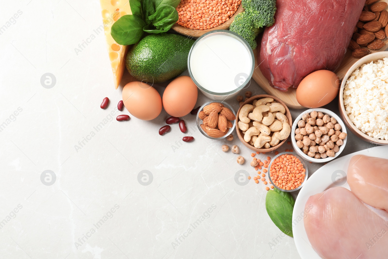 Photo of Set of natural food high in protein and space for text on light background, top view