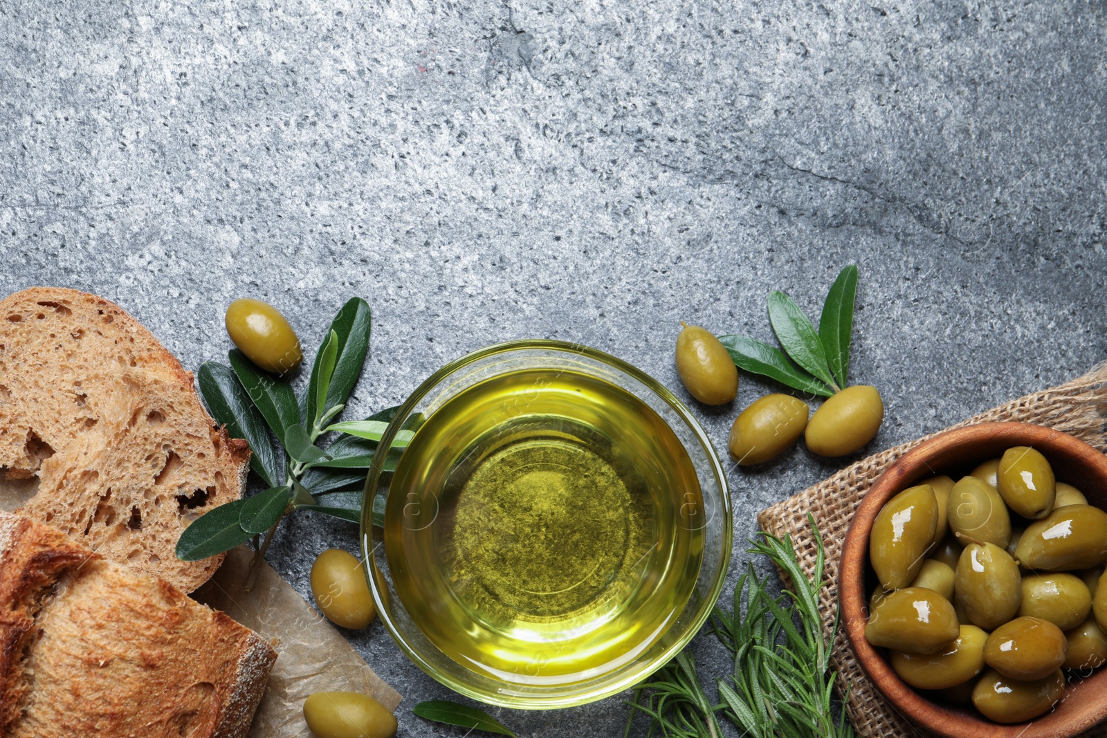 Photo of Flat lay composition with olive oil on grey table, flat lay. Space for text