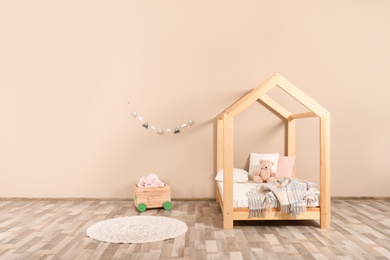 Photo of Stylish child room interior with house bed. Space for text