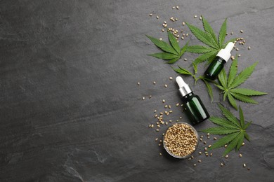 Photo of Flat lay composition with hemp leaves, bottles of CBD oil and THC tincture on black slate table. Space for text