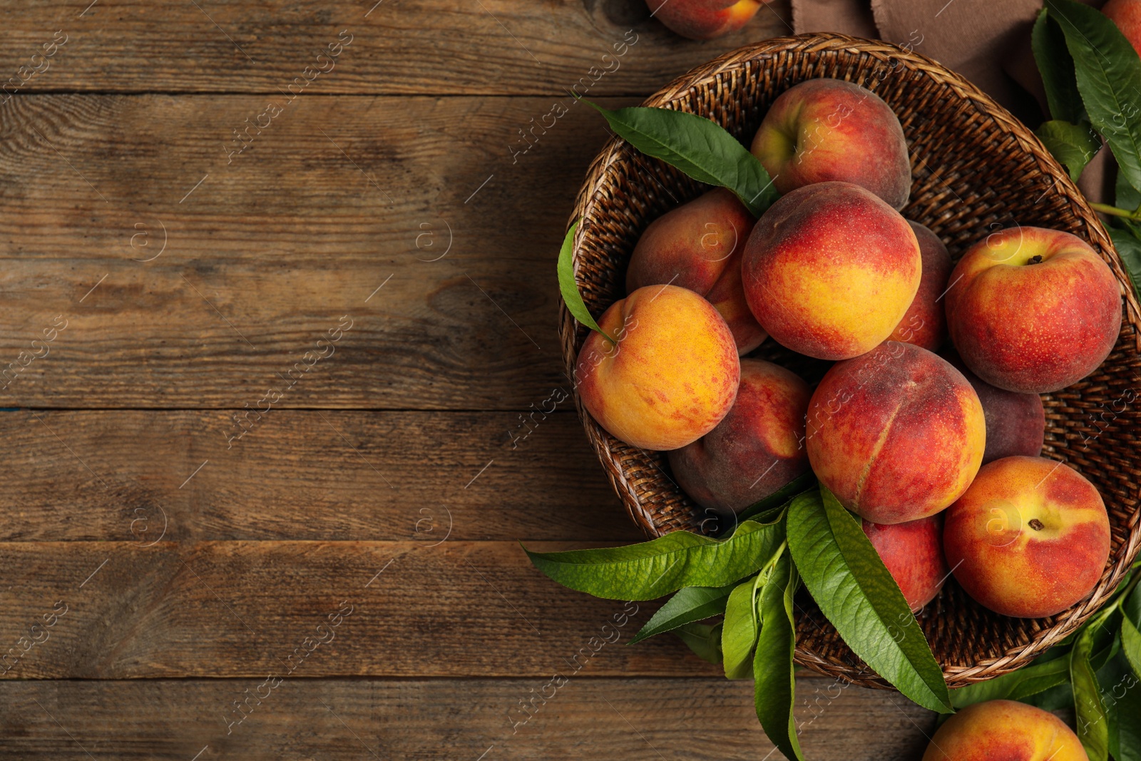Photo of Fresh ripe juicy peaches on wooden table, flat lay. Space for text