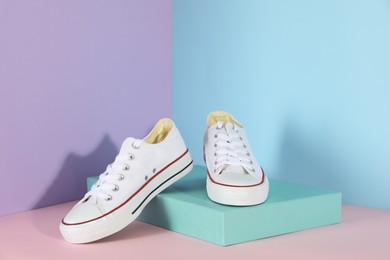 Photo of Pair of stylish sneakers on color background