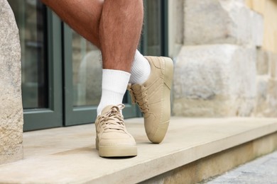 Photo of Man wearing stylish sneakers outdoors, closeup. Space for text