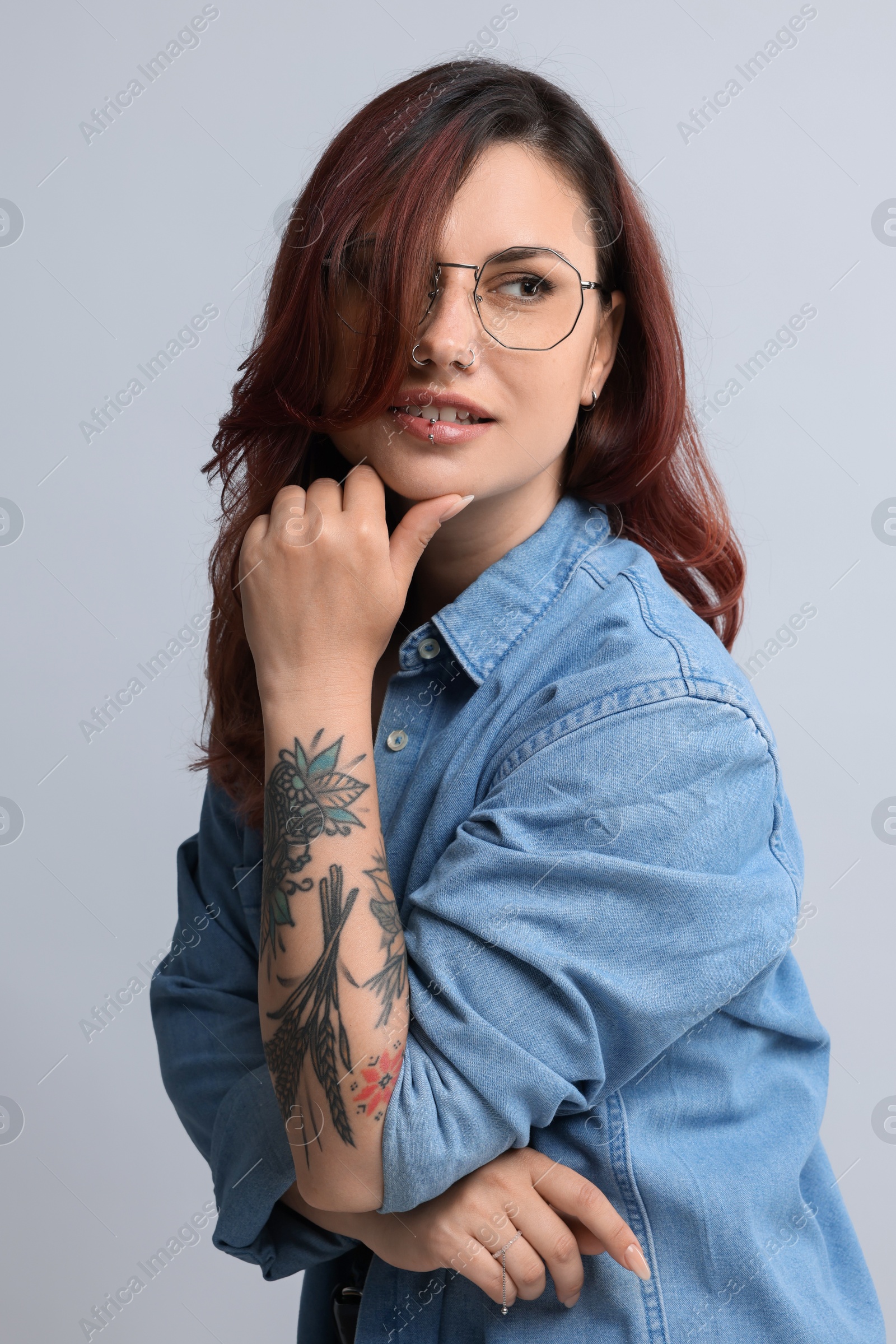 Photo of Portrait of beautiful tattooed woman on gray background