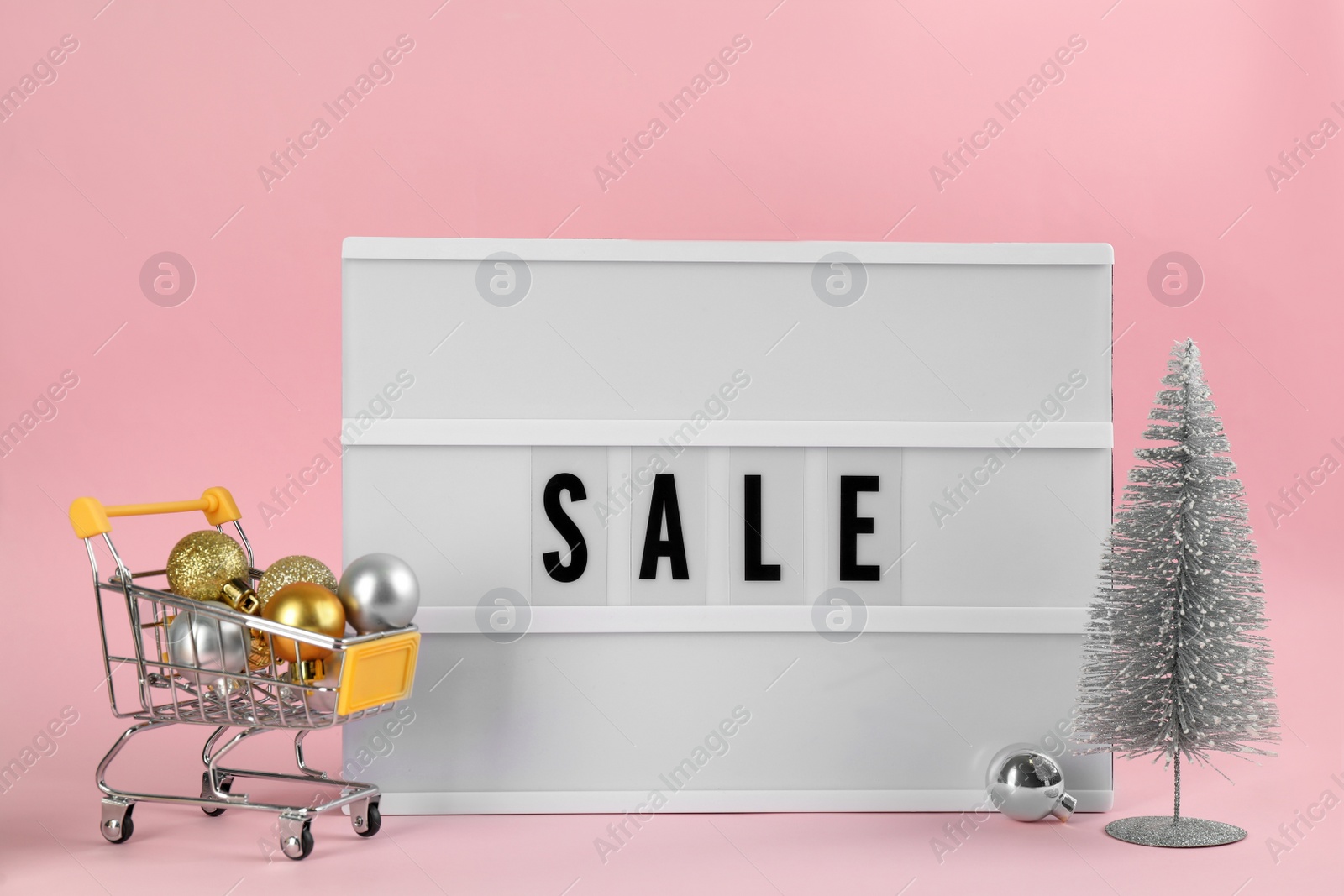 Photo of Lightbox with word Sale and Christmas decor on pink background