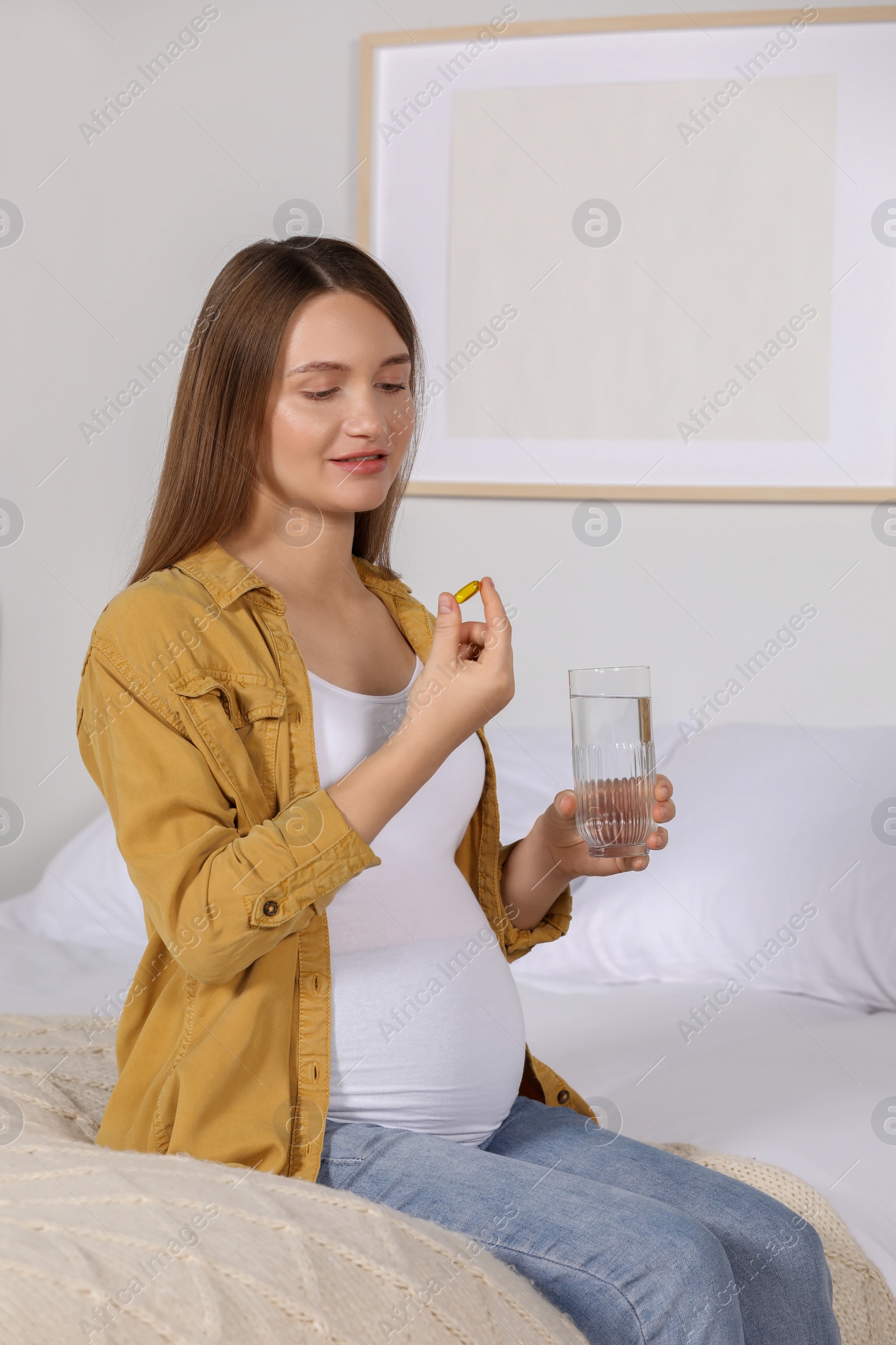 Photo of Beautiful pregnant woman taking pill at home