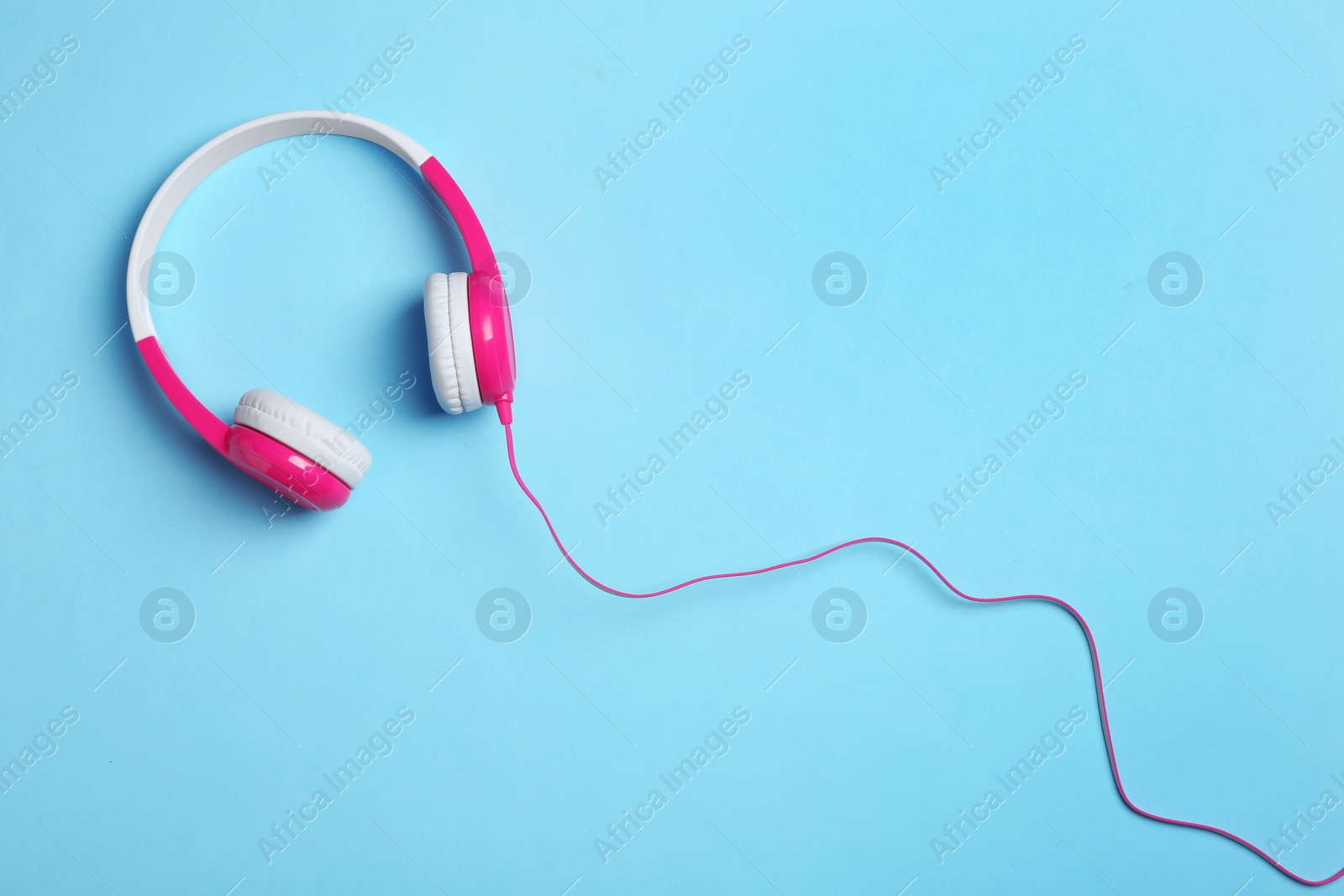 Photo of Stylish headphones on color background, top view. Space for text