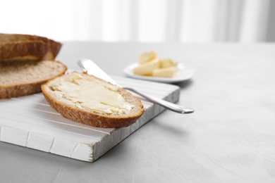 Fresh bread with tasty butter on wooden board