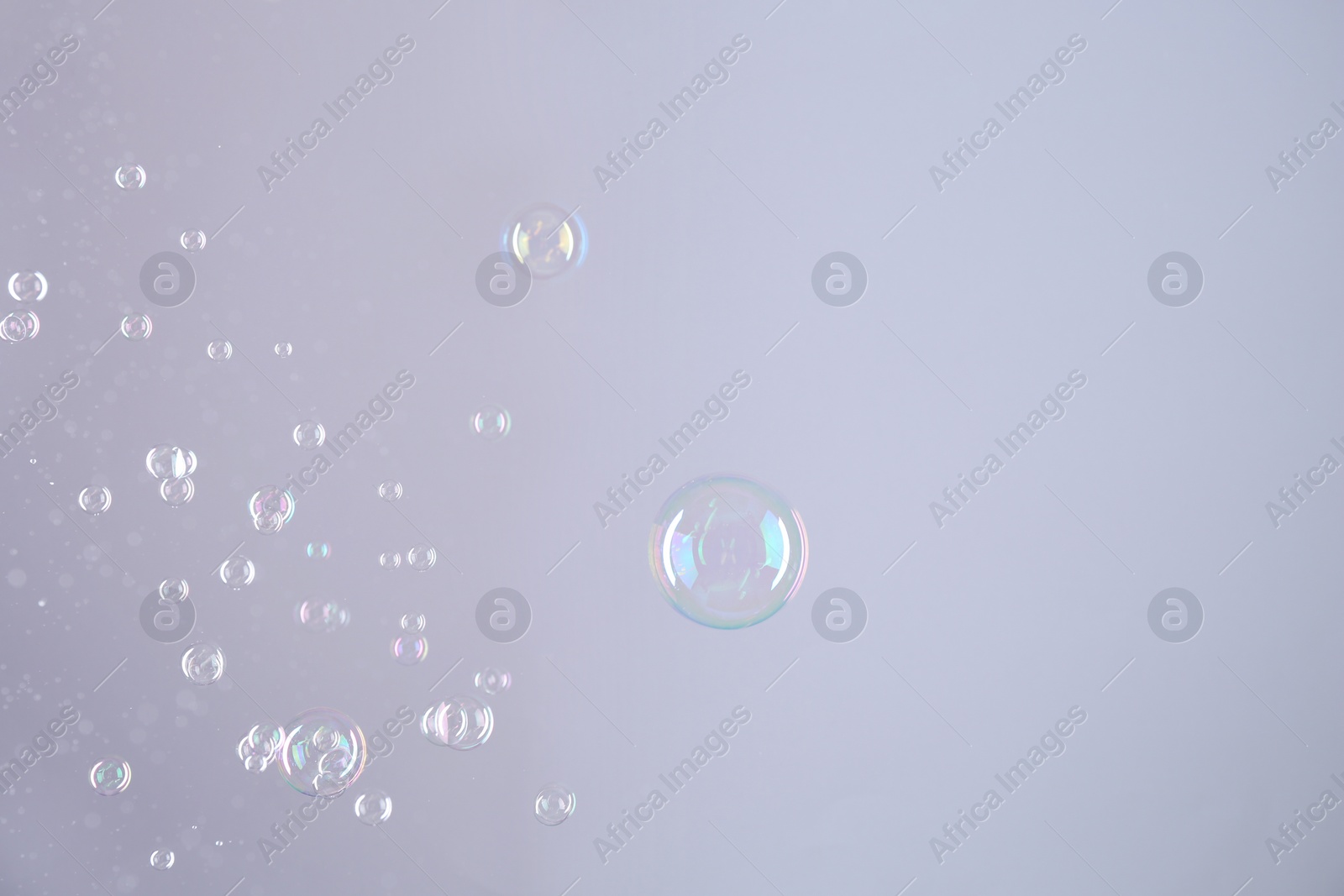 Photo of Beautiful transparent soap bubbles on grey background, space for text