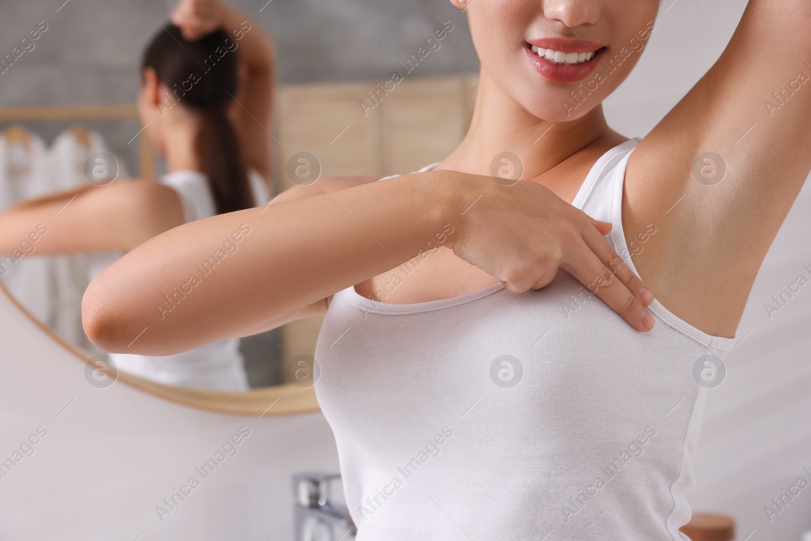 Photo of Woman doing breast self-examination in bathroom, closeup