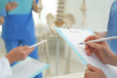 Photo of Female orthopedist with clipboard in clinic, closeup