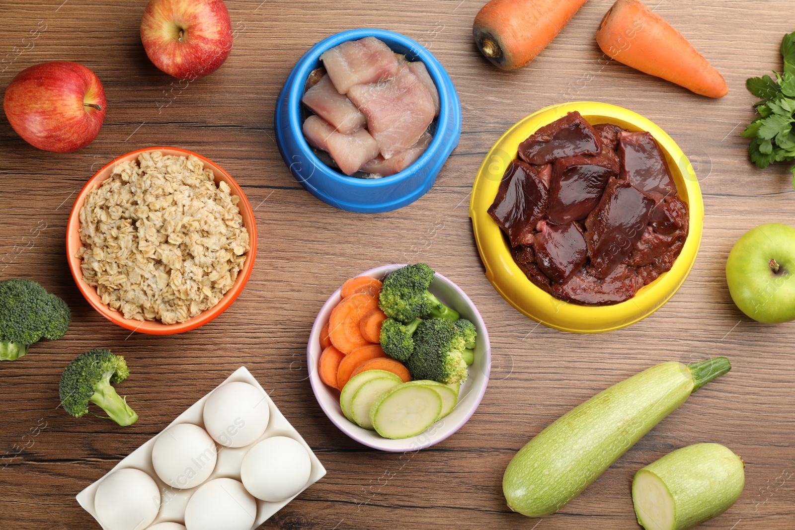 Photo of Pet food and natural ingredients on wooden table, flat lay