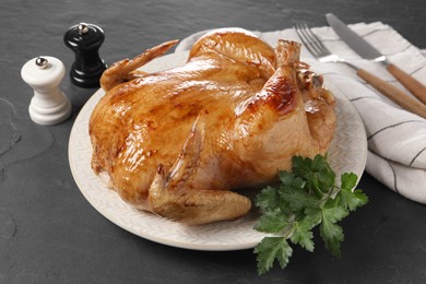 Tasty roasted chicken with parsley served on grey textured table