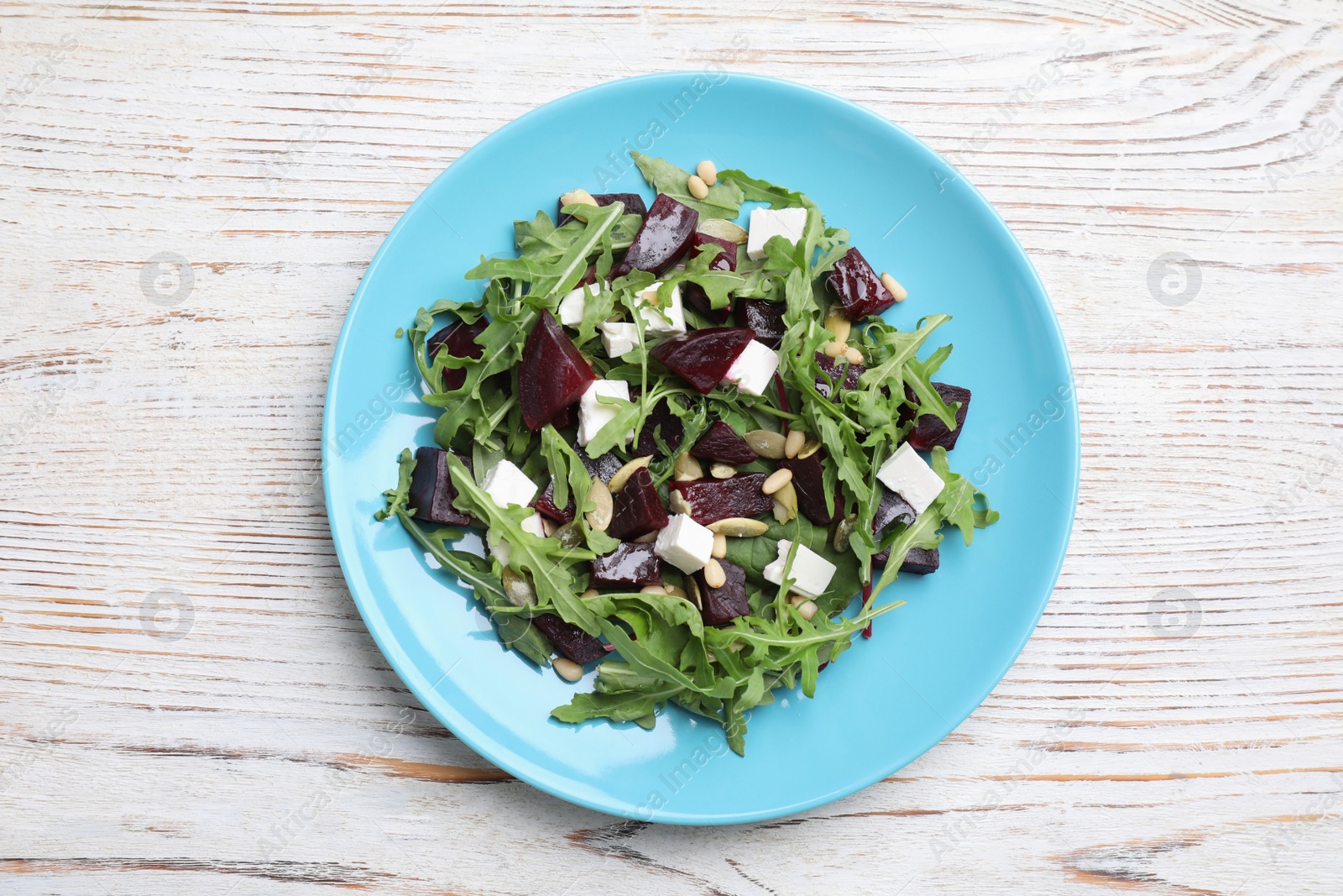 Photo of Fresh delicious beet salad on white wooden table, top view