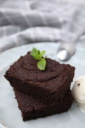 Tasty brownies served with ice cream and mint on table, closeup