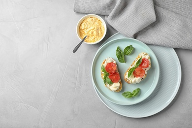 Photo of Tasty fresh tomato bruschettas on grey table, flat lay. Space for text