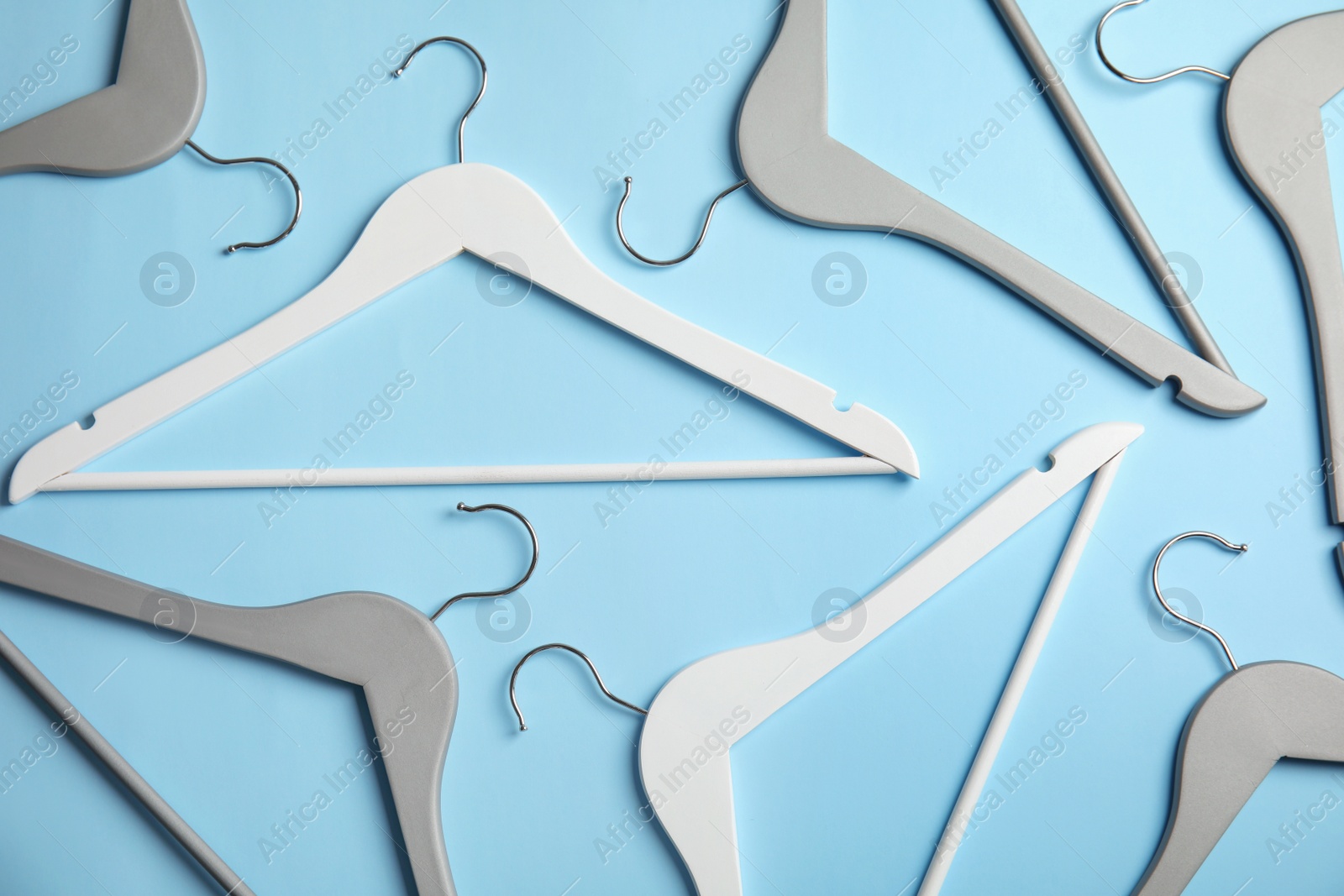 Photo of Flat lay composition with empty hangers on color background