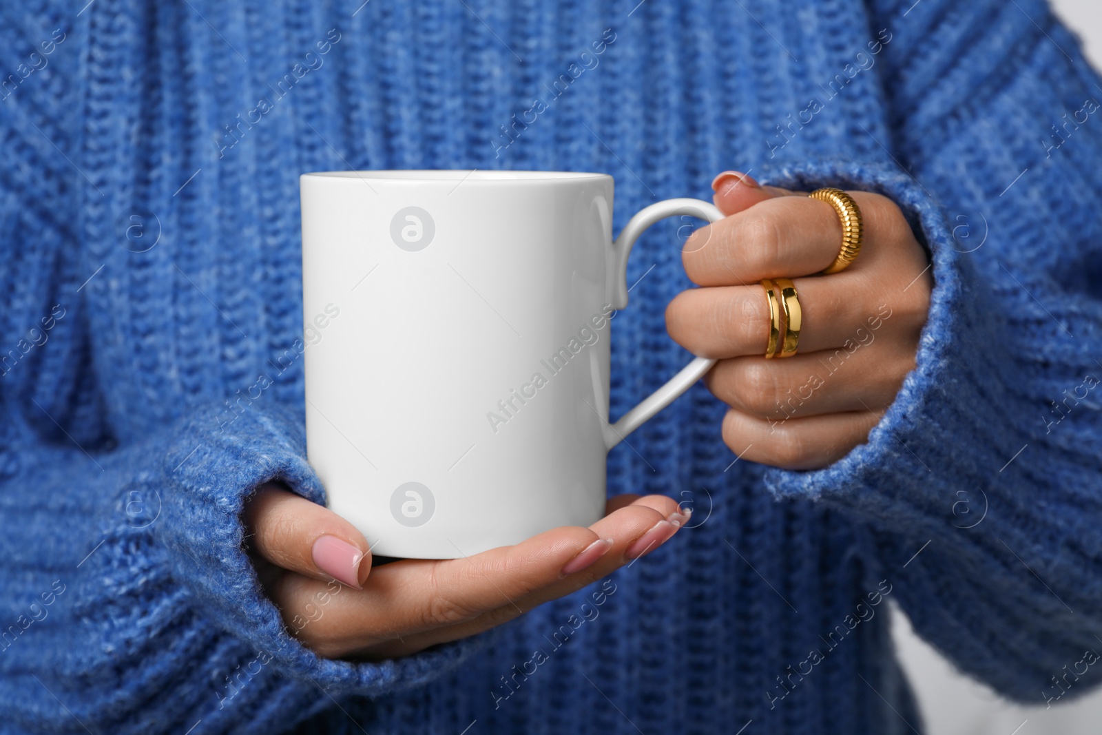 Photo of Woman holding white mug, closeup. Mockup for design