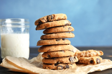 Photo of Chocolate chip cookies and jar of milk on table