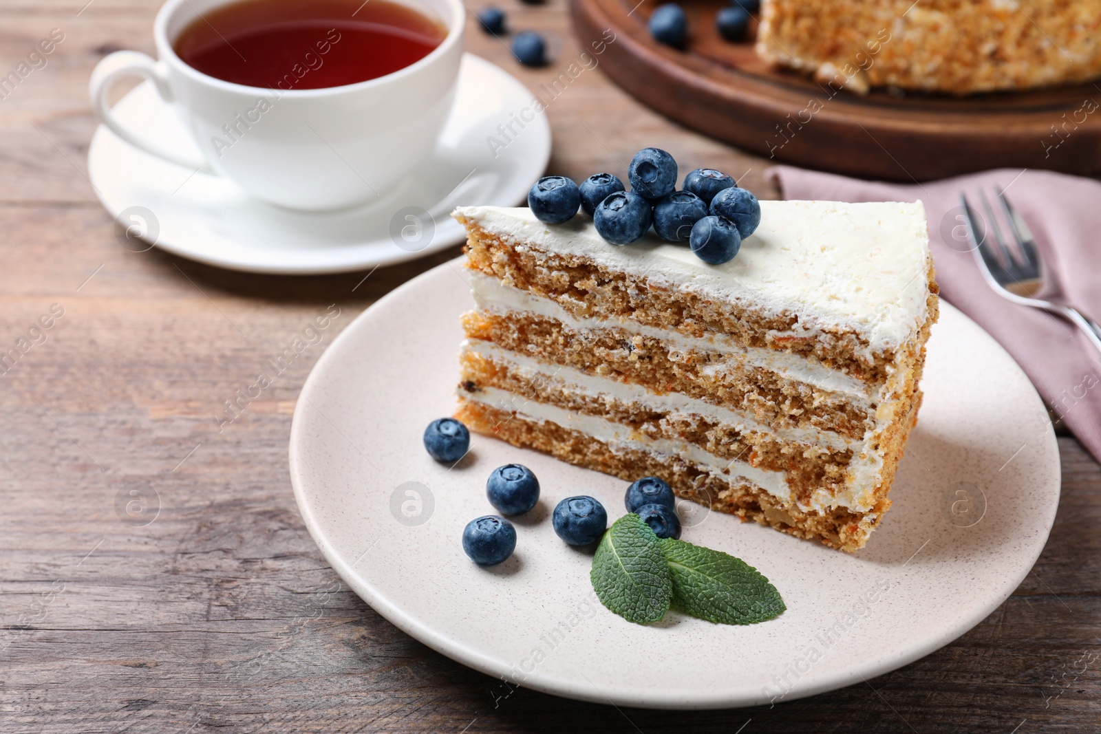 Photo of Tasty cake with berries on wooden table