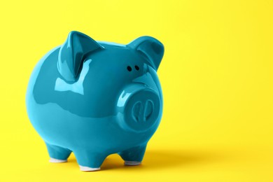 Photo of Ceramic piggy bank on yellow background. Space for text