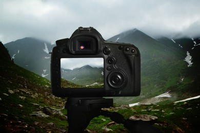 Image of Taking photo of beautiful mountain landscape with camera mounted on tripod