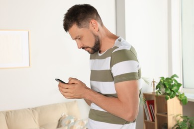 Man with poor posture using smartphone at home