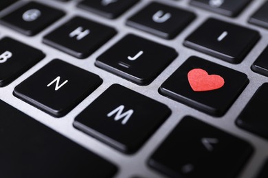 Photo of Heart on laptop keyboard, closeup. Online dating concept