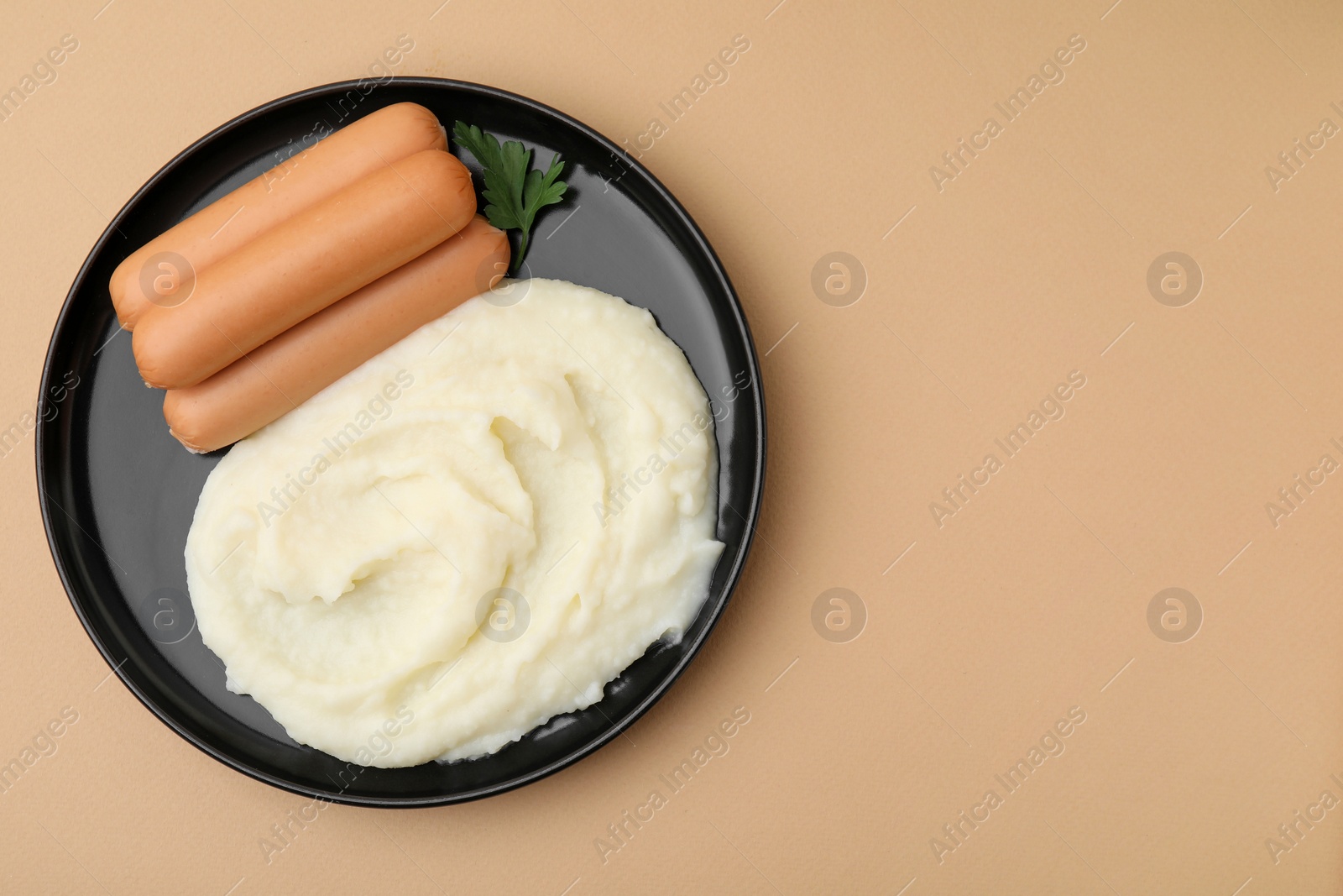 Photo of Delicious boiled sausages, mashed potato and parsley on beige background, top view. Space for text