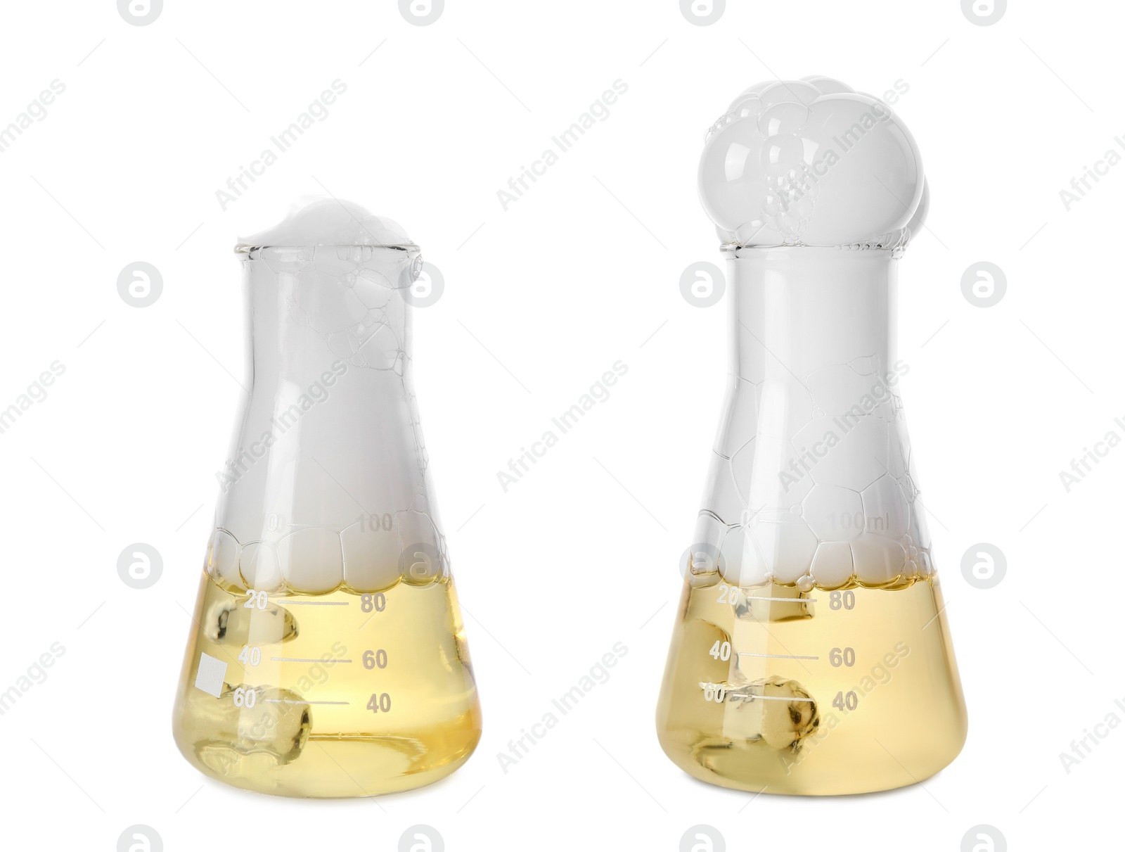 Image of Laboratory flasks with yellow liquid and foam on white background. Chemical reaction