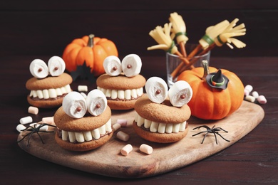 Photo of Delicious Halloween themed desserts on wooden table