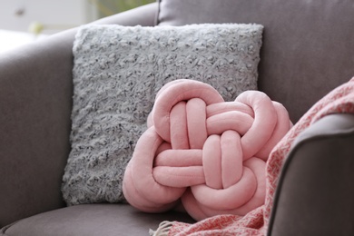 Photo of Pillows and plaid on armchair. Idea for interior design